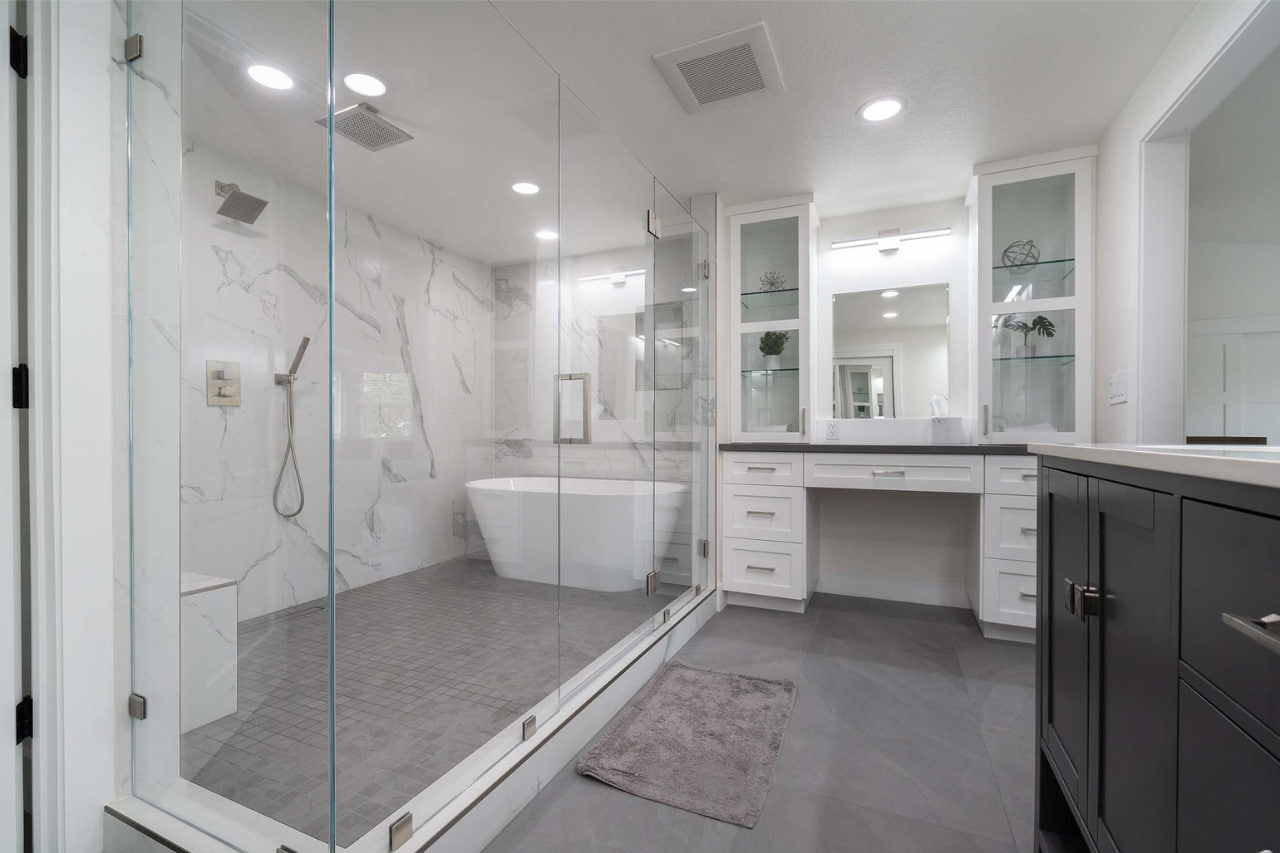 Professional remodeling by bathroom contractors in San Jose delivering sleek tub-shower combination with frameless glass enclosure and white tile